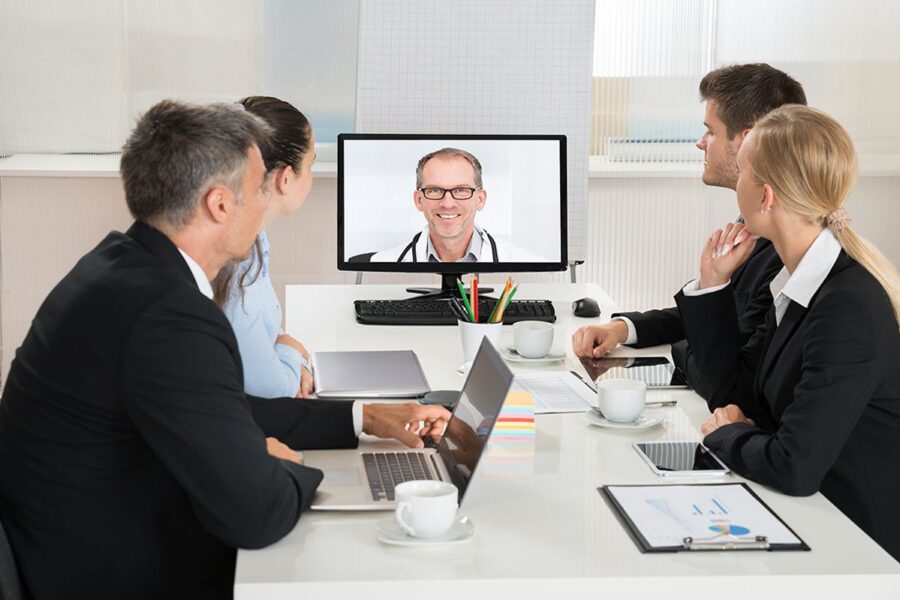 CareVitality, a Virtual Care Management Company | CCM RPM PCM BHI & TCM 7 Team of businesspeople video conferencing with a doctor